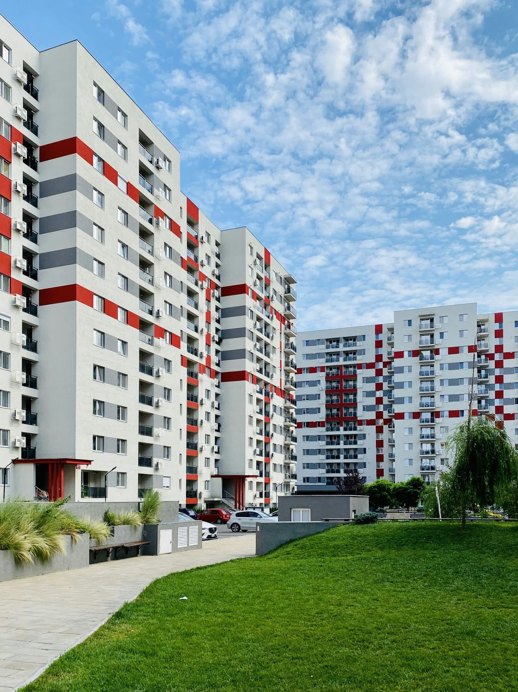 Demo image. White and red apartment buildings above a lawn.